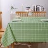 مفرش طاولة بلاستيك لون أخضر فاتح بنقشة هندسية مقاوم للبقع. Light green PVC tablecloth with geometric pattern, spill-resistant on a rectangular table.